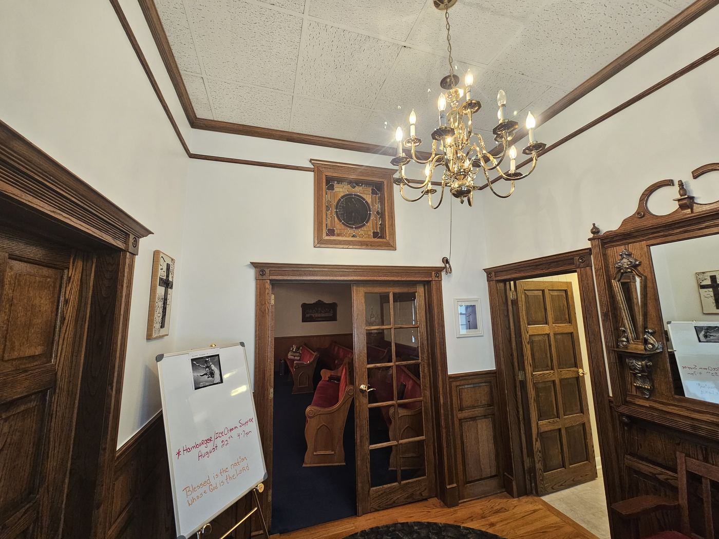 Church entry with painted walls, wood trim, and a stained-glass window of Jesus.